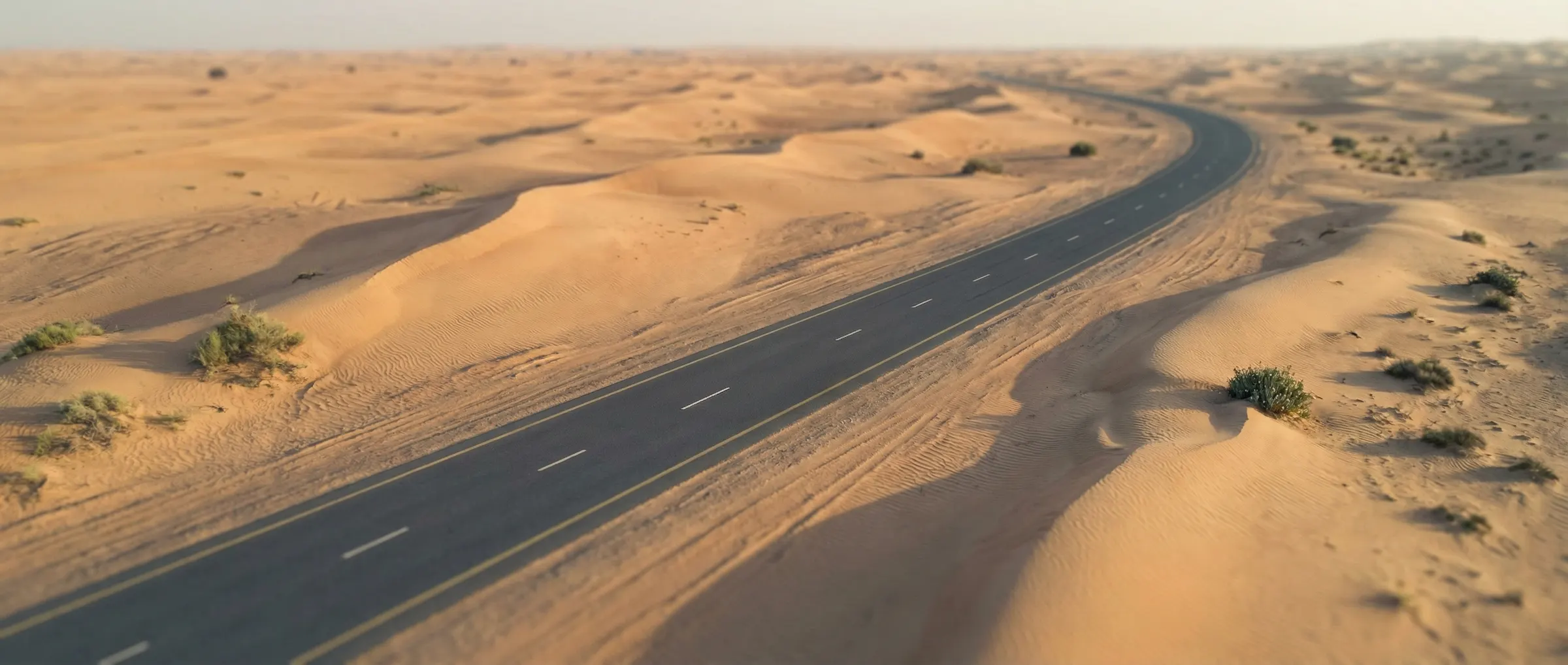 A single road cutting through the Empty Quarter at first light — the Dubai desk's field note