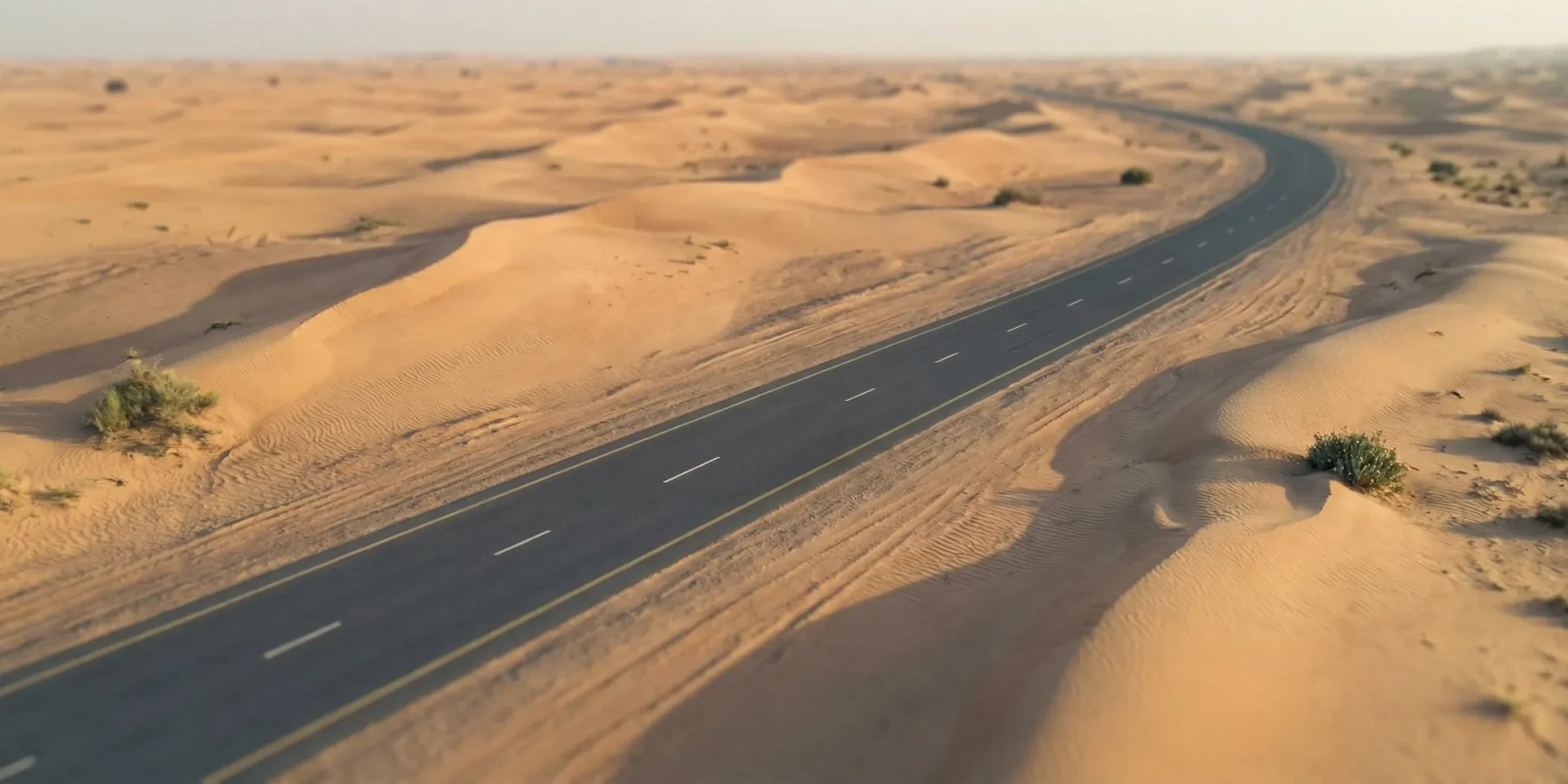 A single road cutting through the Empty Quarter at first light — the Dubai desk's field note